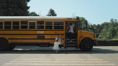 妈妈。陪儿子学校运输学校男孩登机黄色的公共汽车